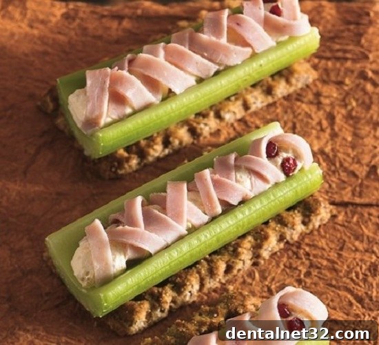 Celery sticks with cream cheese and deli meat strips, resembling a mummy for Halloween.