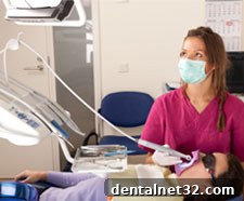 A dentist using an intra-oral camera to show a patient their teeth on a screen.