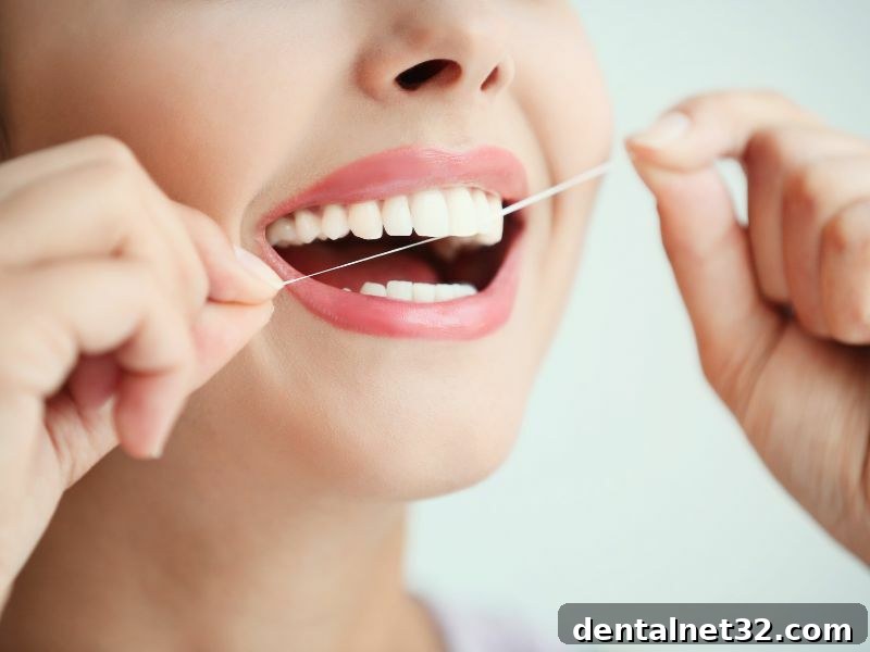 A person flossing their teeth in front of a mirror to maintain oral hygiene.