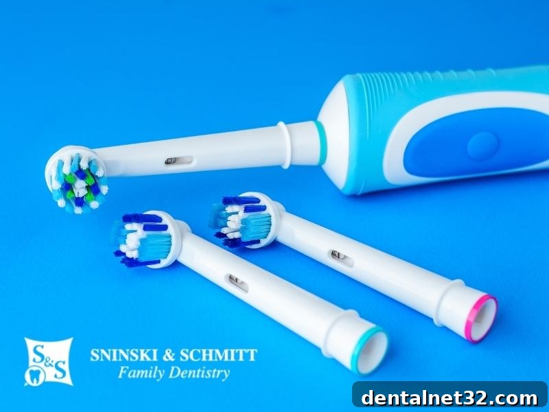 A person smiling while holding a modern electric toothbrush.